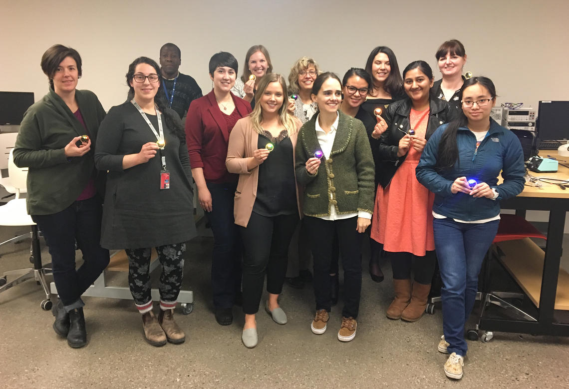 A dozen glowing success stories at the She Leads: Soldering Workshop, hosted by the Schulich School of Engineering as part of Women in Work Week at the University of Calgary. The man in the back row is Chris Simon, soldering instructor and electrical and computer engineering technician at Schulich.