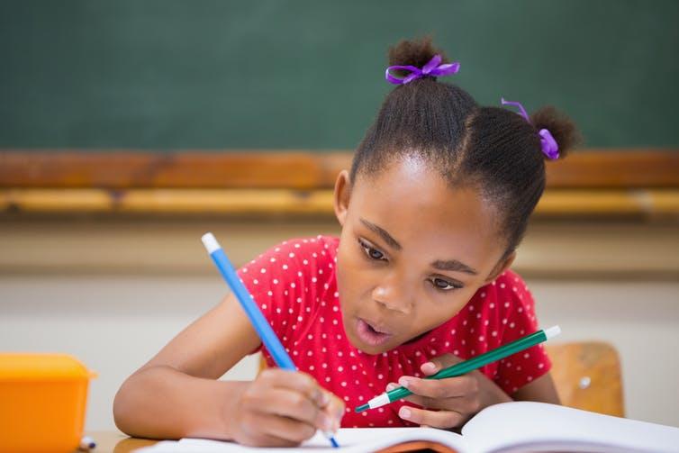 Young girl writing in book