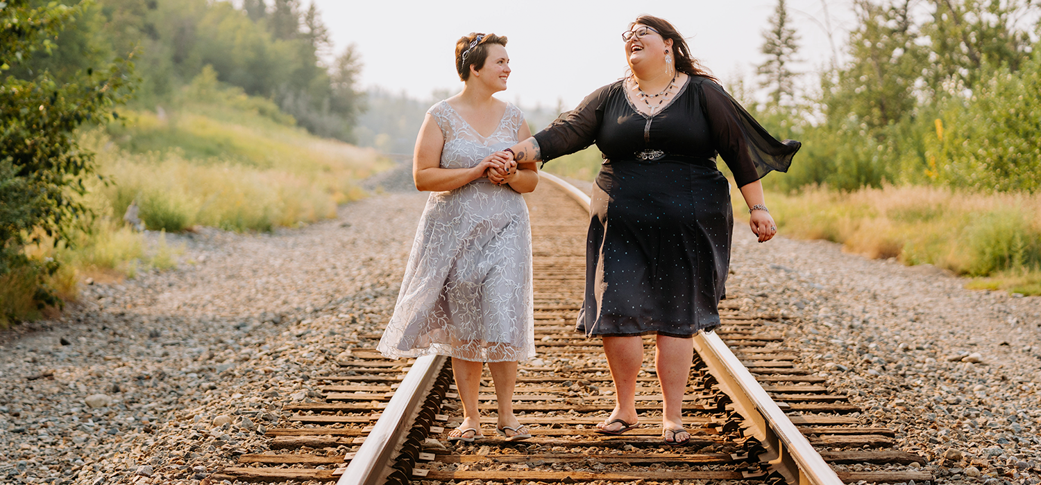 Katie Delucia Burk and her wife Emily walk on train tracks